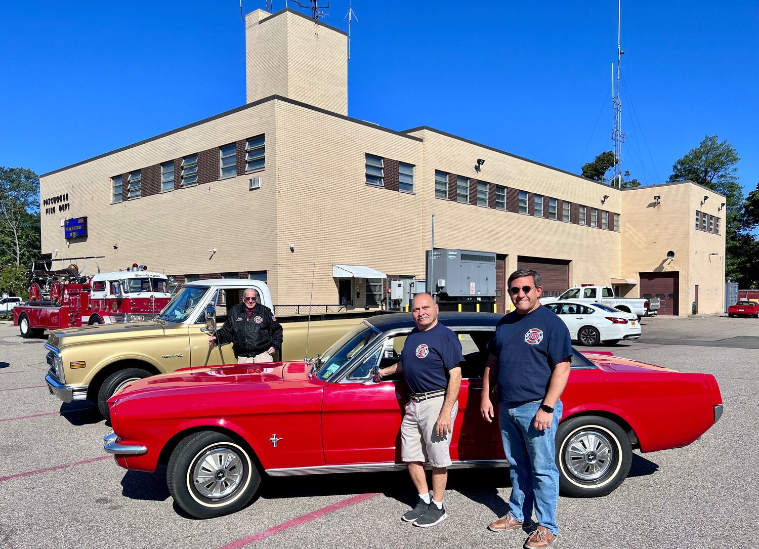 Patchogue firefighters Ronnie Donato (left) and Dan Brooks in front of the Donato brothers’ 1966 Ford Mustang. In back is former Patchogue fire chief Paul Felice with his 1960 Mac Truck.